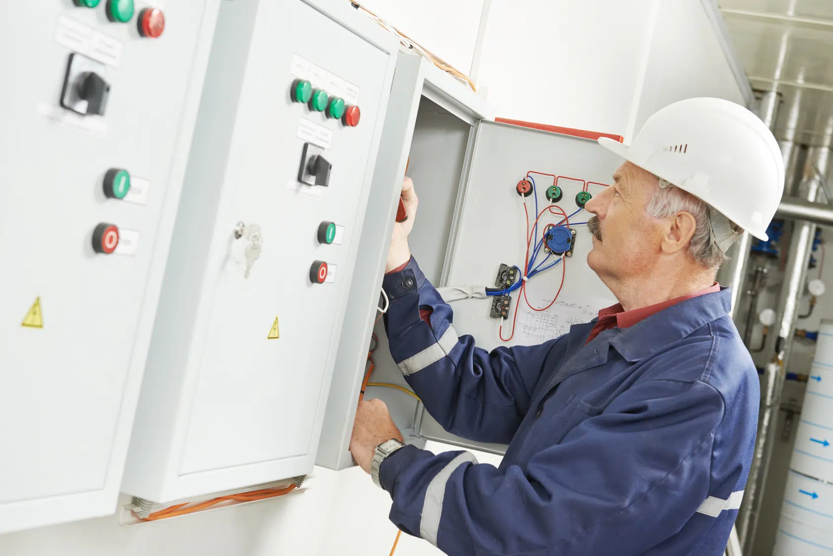 senior adult electrician builder engineer testing equipment in fuse box